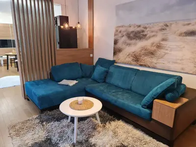 a living room with a blue couch and a table at Dimiant Lux Apartment in Vračar (historical)