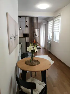 a dining room table with a vase of flowers on it at Dimiant Lux Apartment in Vračar (historical)