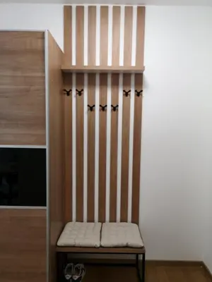a wooden bench in a room with a wall at Dimiant Lux Apartment in Vračar (historical)