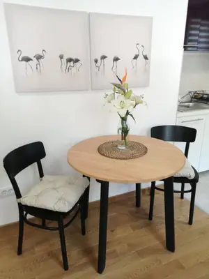 a dining room table with two chairs and a vase with flowers at Dimiant Lux Apartment in Vračar (historical)