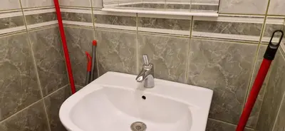 a bathroom with a white sink and red pipes at Julija 3 in Pančevo