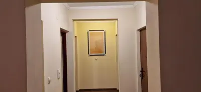 a hallway with a yellow door and a picture on the wall at Julija 3 in Pančevo