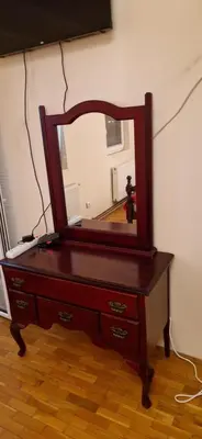 a wooden dresser with a mirror on top of it at Julija 3 in Pančevo