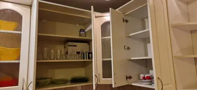 a white cabinet with glass doors in a kitchen at Julija 3 in Pančevo