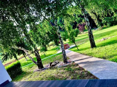 a sidewalk in a park with trees and grass at Imanje POGLED in Arandjelovac