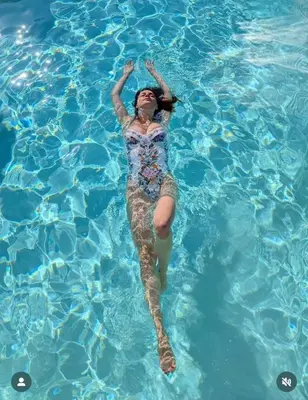 a woman floating in a pool of water at Imanje POGLED in Arandjelovac