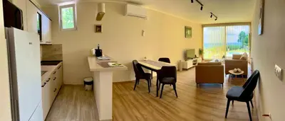 a kitchen and living room with a table and chairs at Imanje POGLED in Arandjelovac