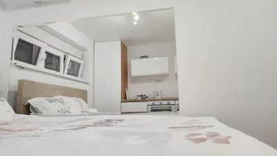 a white room with a bed and a kitchen at Milash in Karaburma