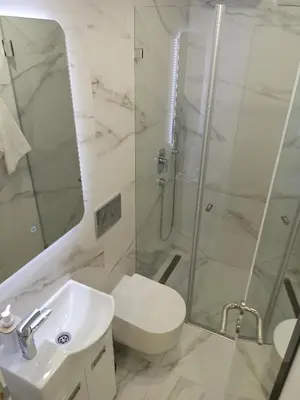 a bathroom with a shower and a toilet and a sink at Milash in Karaburma