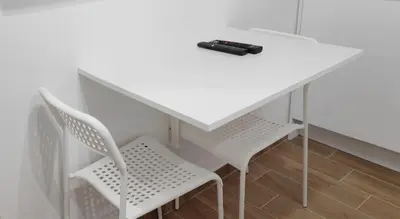 a white table with two chairs and a remote control on it at Milash in Karaburma