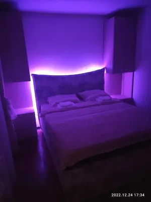 a bedroom with a bed with a purple lighting at Stan na dan in Resnik