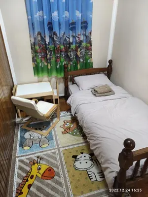 a small bedroom with a bed and a chair and a window at Stan na dan in Resnik