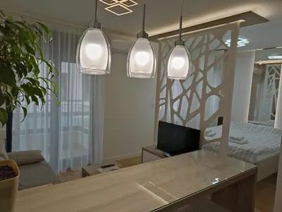 a living room with a table and three pendant lights at Galija apartment in Belgrade