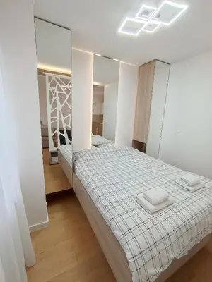a bedroom with a bed and a mirror at Galija apartment in Belgrade