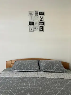 a bed with two pillows and posters on the wall at Apartman Dunja in Arandjelovac