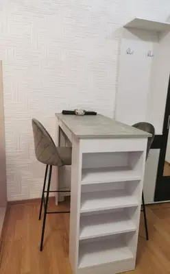 a desk with a chair and a table and shelves at Gorila 1 in Voždovac