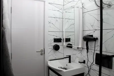 a white bathroom with a sink and a mirror at Gorila 1 in Voždovac
