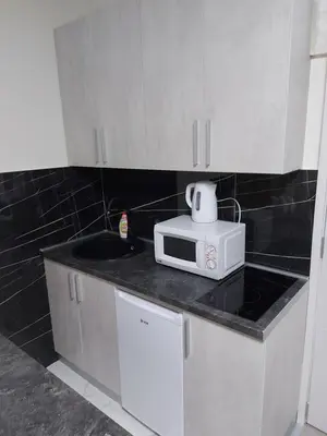 a kitchen with white cabinets and a microwave on a counter at Apartman mikikiki in Belgrade