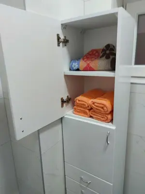 a bathroom with white cabinets and towels at Apartman mikikiki in Belgrade