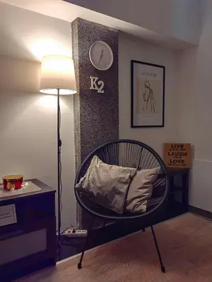 a room with a chair and a clock on the wall at Apartman K2 in Žarkovo