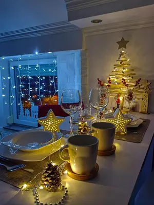 a dining table with wine glasses and a christmas tree at Apartman K2 in Žarkovo