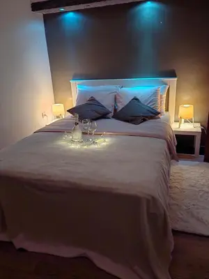 a bedroom with a large white bed with lights on it at Apartman K2 in Žarkovo