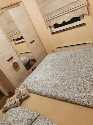 an attic bedroom with a bed and a mirror at Lux apartman Lena in Belgrade