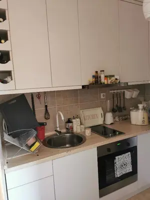 a kitchen with white cabinets and a sink at Lux apartman Lena in Belgrade