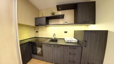 a kitchen with dark wood cabinets and a sink at Apart Hotel Maksimum in Belgrade