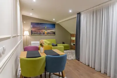 a dining room with a table and chairs and a couch at Apart Hotel Maksimum in Belgrade
