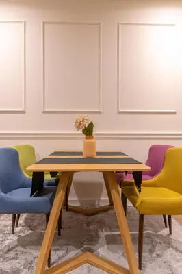 a table with colorful chairs in a room at Apart Hotel Maksimum in Belgrade