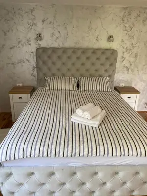 a large white bed with two towels on it at Apartman17 in Belgrade