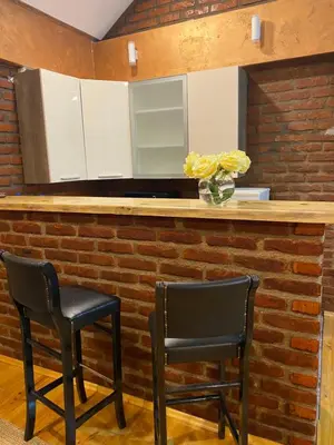 a kitchen with two chairs and a counter with white cabinets at Apartman17 in Belgrade