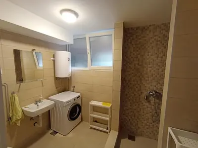a bathroom with a washing machine and a sink at Apartment Fiesta in Novi Beograd