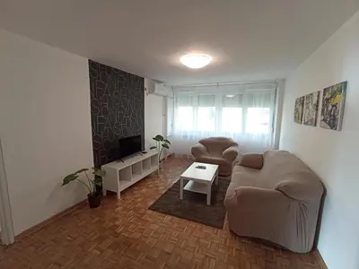 a living room with a couch and chairs and a tv at Apartment Fiesta in Novi Beograd