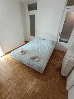 a bedroom with a bed with two slippers on it at Apartment Fiesta in Novi Beograd