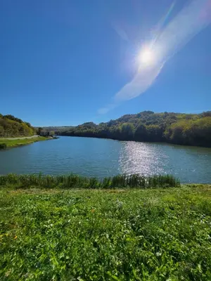 a view of a river with the sun in the sky at Vila lake in Karaula