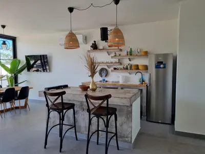 a kitchen with a table with chairs and a refrigerator at Vila lake in Karaula
