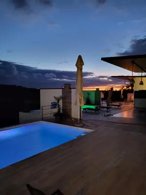 a pool on the roof of a building with a sunset at Vila lake in Karaula