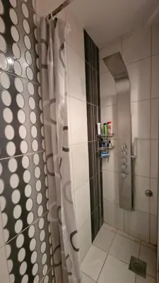a shower with a shower curtain in a bathroom at Sava Centar in Novi Beograd