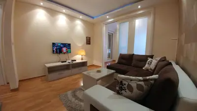 a living room with a couch and a tv at Delta Residence Belville in Belgrade