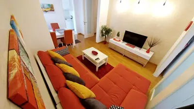 a living room with a red couch and a television at Delta Residence Belville in Belgrade