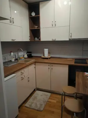 a kitchen with white cabinets and a table and chairs at Kapetan Misina-Nina in Belgrade