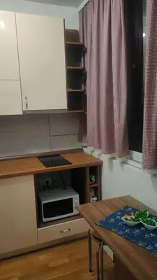 a small kitchen with a table and a microwave at Kapetan Misina-Nina in Belgrade
