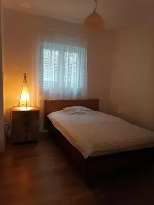 a bedroom with a bed with a lamp and a window at Kapetan Misina-Nina in Belgrade