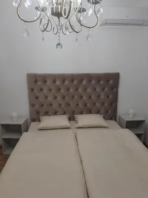 a bedroom with a large bed and a chandelier at Apartman Marija in Voždovac