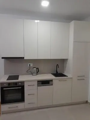 a kitchen with white cabinets and a sink at Apartman Marija in Voždovac