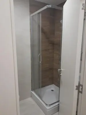 a shower with a glass door in a bathroom at Apartman Marija in Voždovac