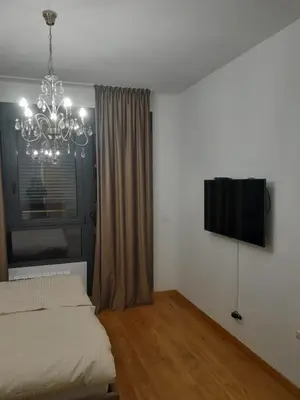 a bedroom with a bed and a chandelier at Apartman Marija in Voždovac