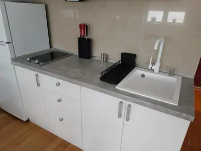 a kitchen counter with a sink and a laptop on it at WHITE apartment in Belgrade